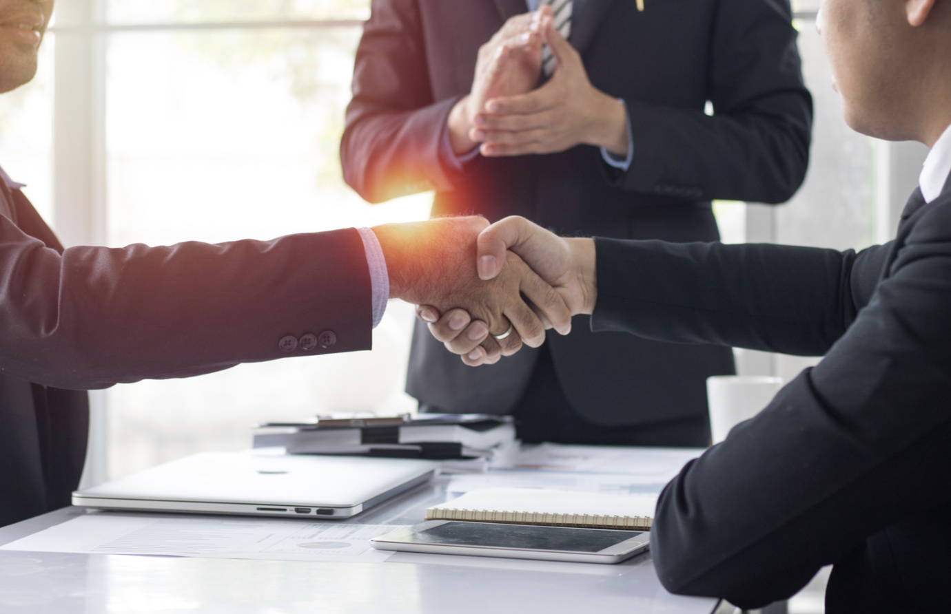 two business professionals shaking hands to represent sale of business